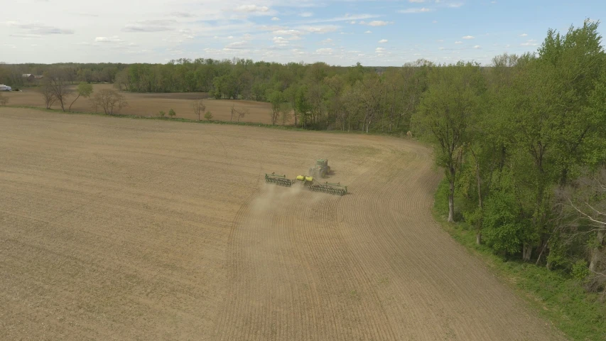 an aerial view of two farm tractors in a field