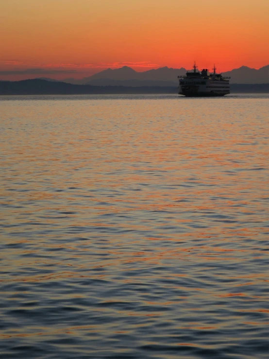 a boat sailing across an ocean near the sun