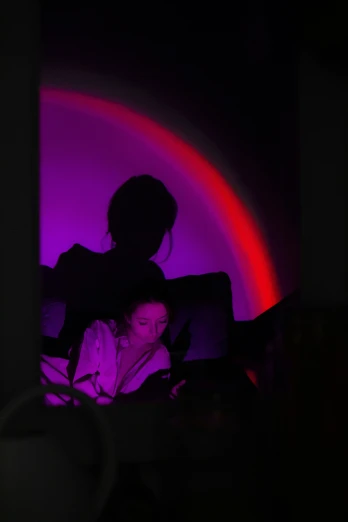 the silhouette of two people who are sitting in a bed