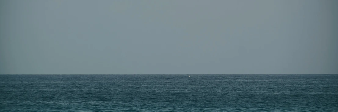 a small boat floating in the middle of the ocean