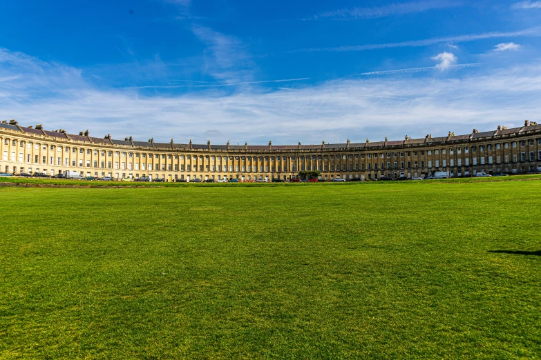 a large building with many windows is on a green grass area