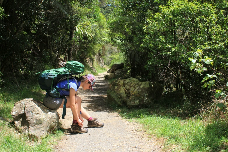 a woman is sitting on a rock and touching the ground