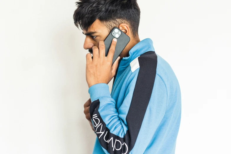 man talking on phone while wearing blue shirt