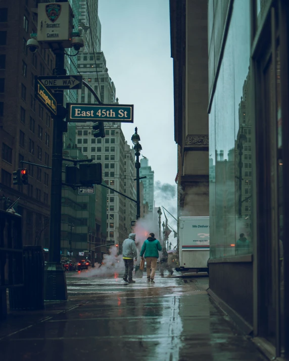 a street scene with people walking the wet streets