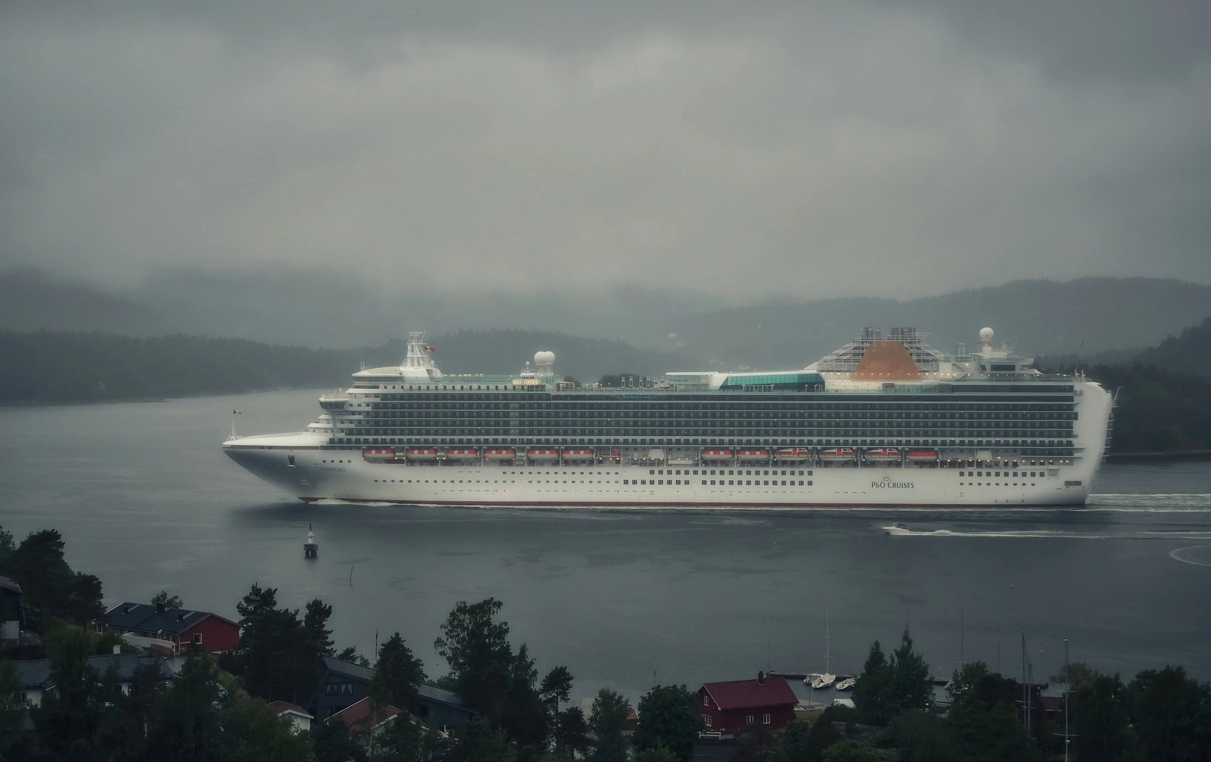 a cruise ship sailing through the ocean on a foggy day