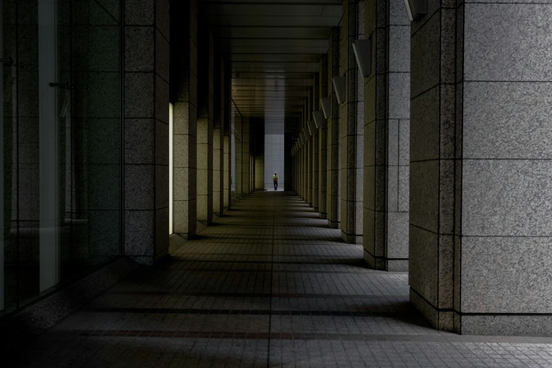 long walkway in dark building, with light on the floor
