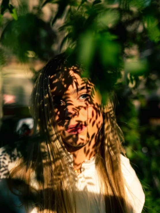 a woman with long hair is holding onto leaves