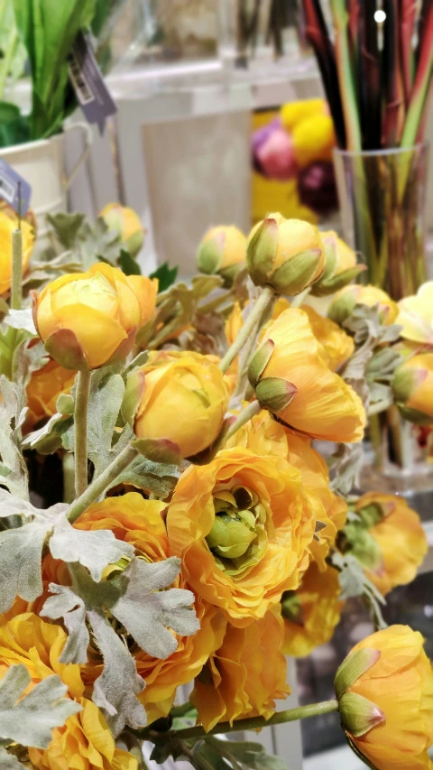 some yellow flowers in a vase on a table