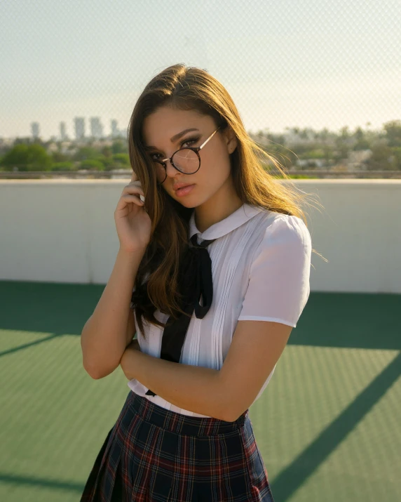 a woman standing on top of a tennis court wearing glasses