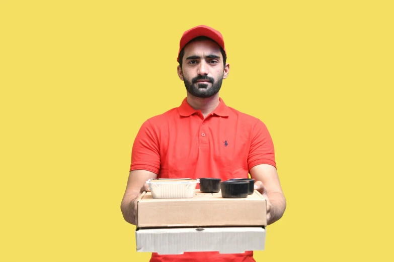 a man holding a carton of pizza