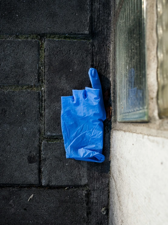 blue material sitting on the side of a building next to a window