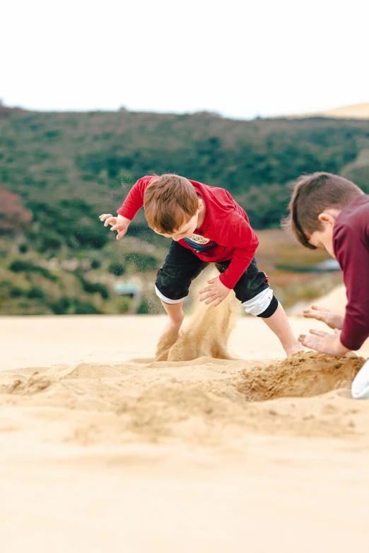 two men and a little girl playing in the sand