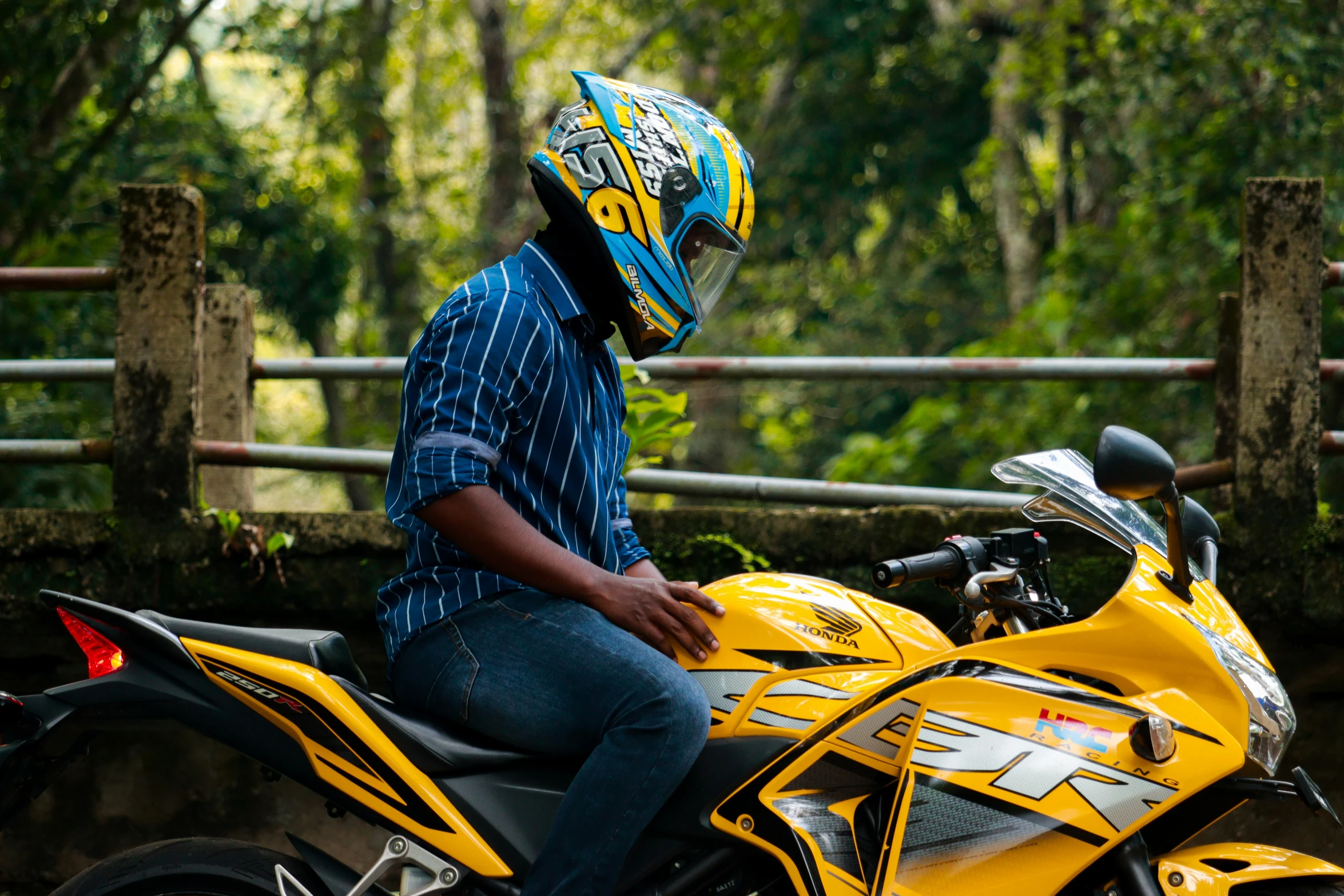 a person wearing a helmet and sitting on a yellow motorcycle