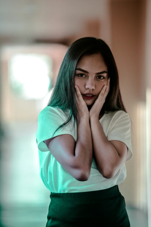 a young woman covering her face with both hands