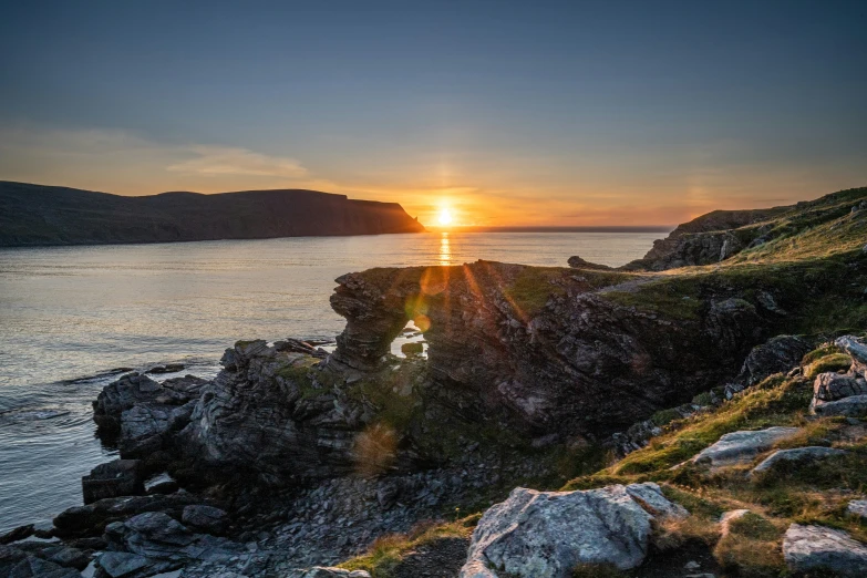 the sun setting over a small body of water