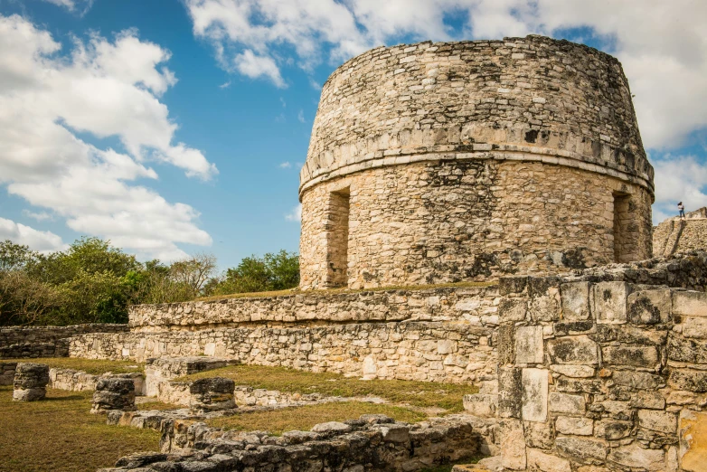 a stone structure built into the ground by the grass