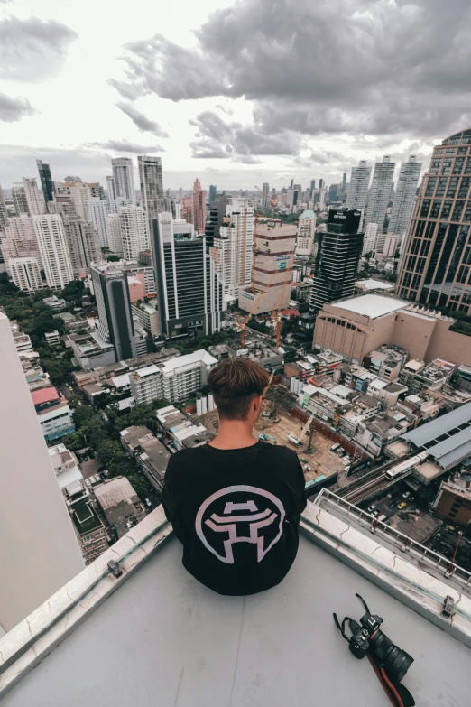 a man with brown hair sitting on top of a roof