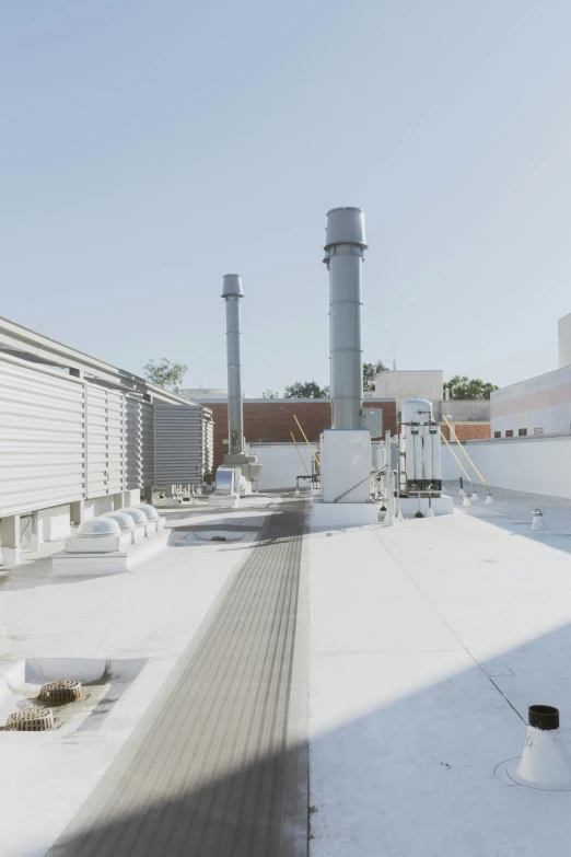 an outdoor area with a snow covered roof, many pipes and structures in it