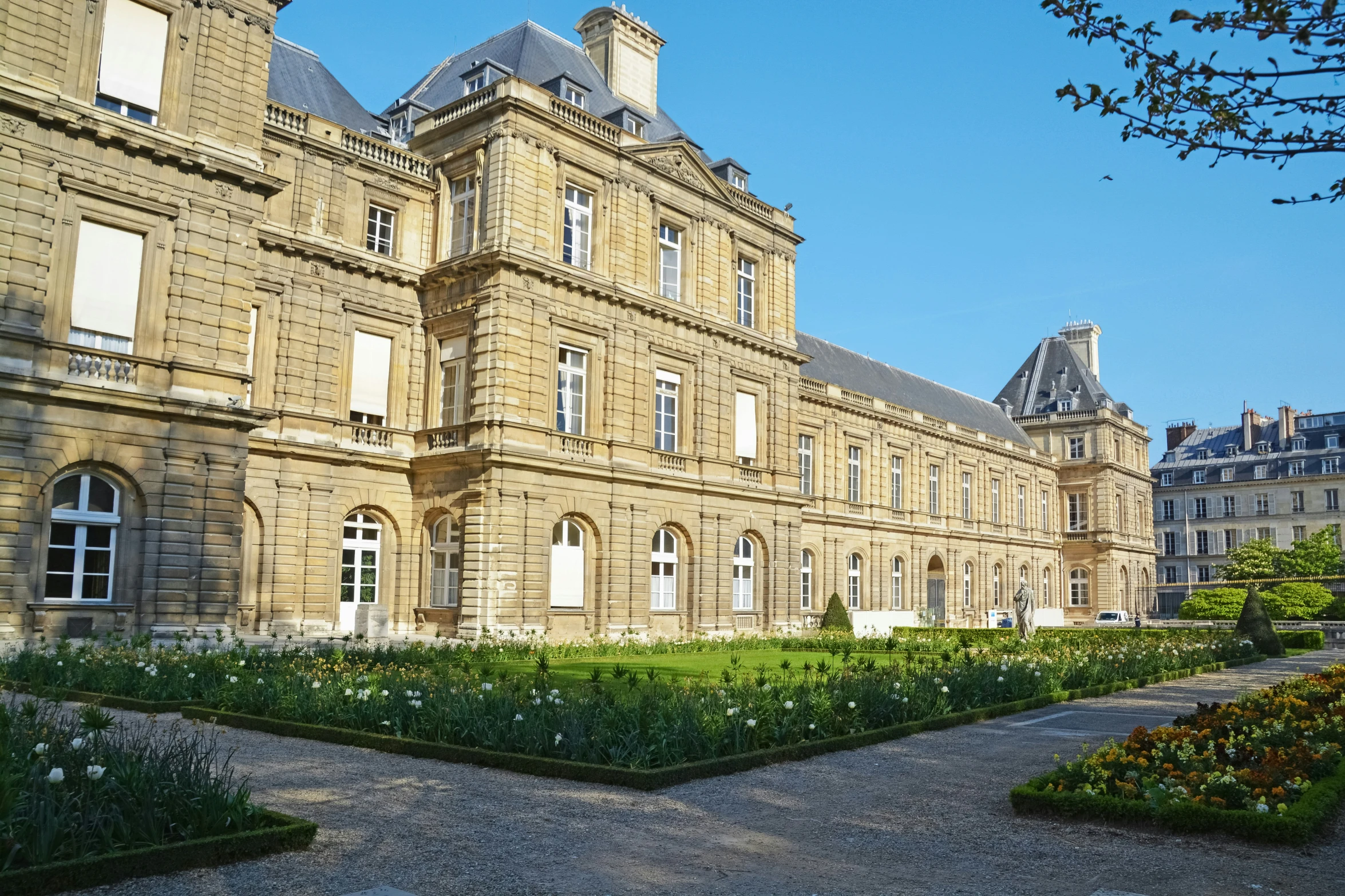 a courtyard, grass area and building that has plants on both sides