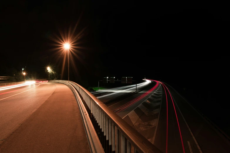an empty highway at night with light trails
