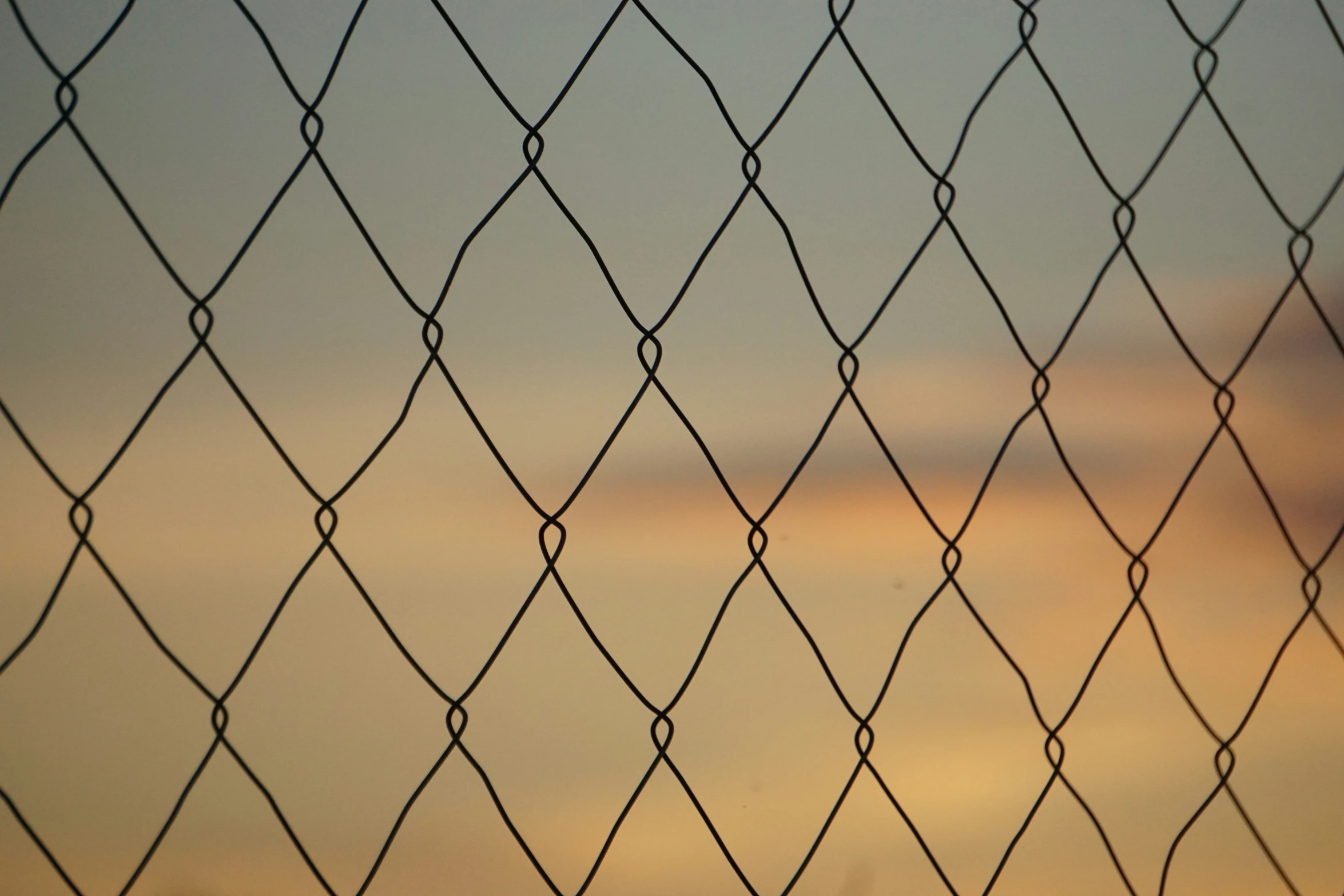 an image of a chain link fence looking like a sunset