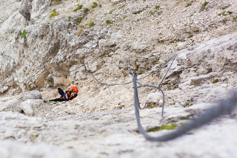 a climber is climbing up a mountain with one hand reaching the ground