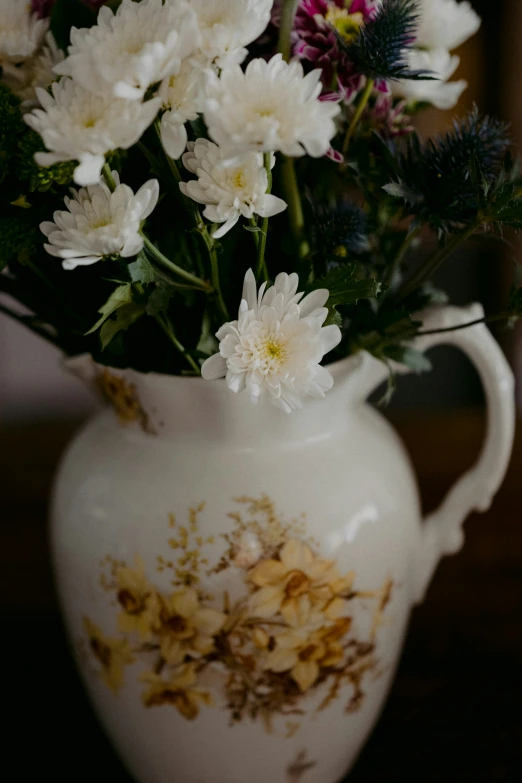 white flowers are being displayed in the white vase