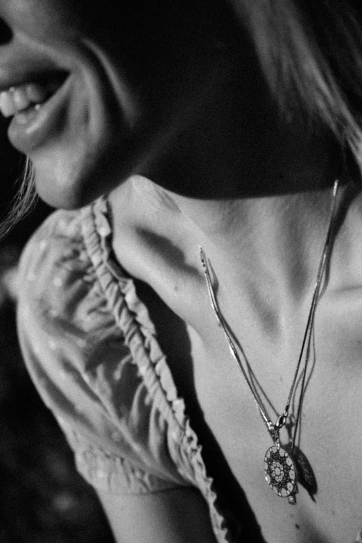 a woman wearing some nice necklaces with a smile on her face