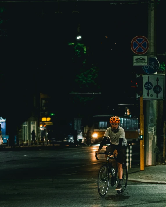 a man on a bicycle riding at night in the street