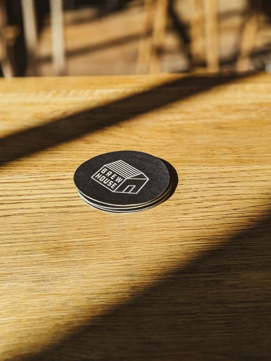 a round wooden table with a small black dot on top