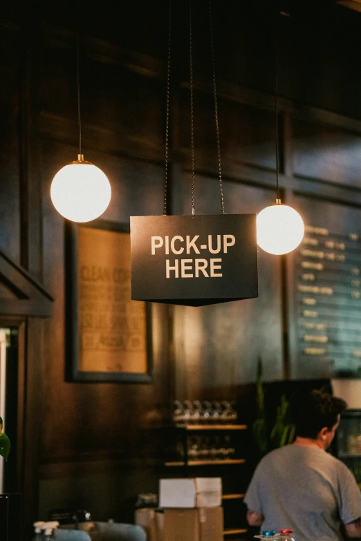 a restaurant with a sign saying pick up here hanging from the ceiling