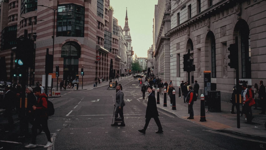 people are crossing the street in a city