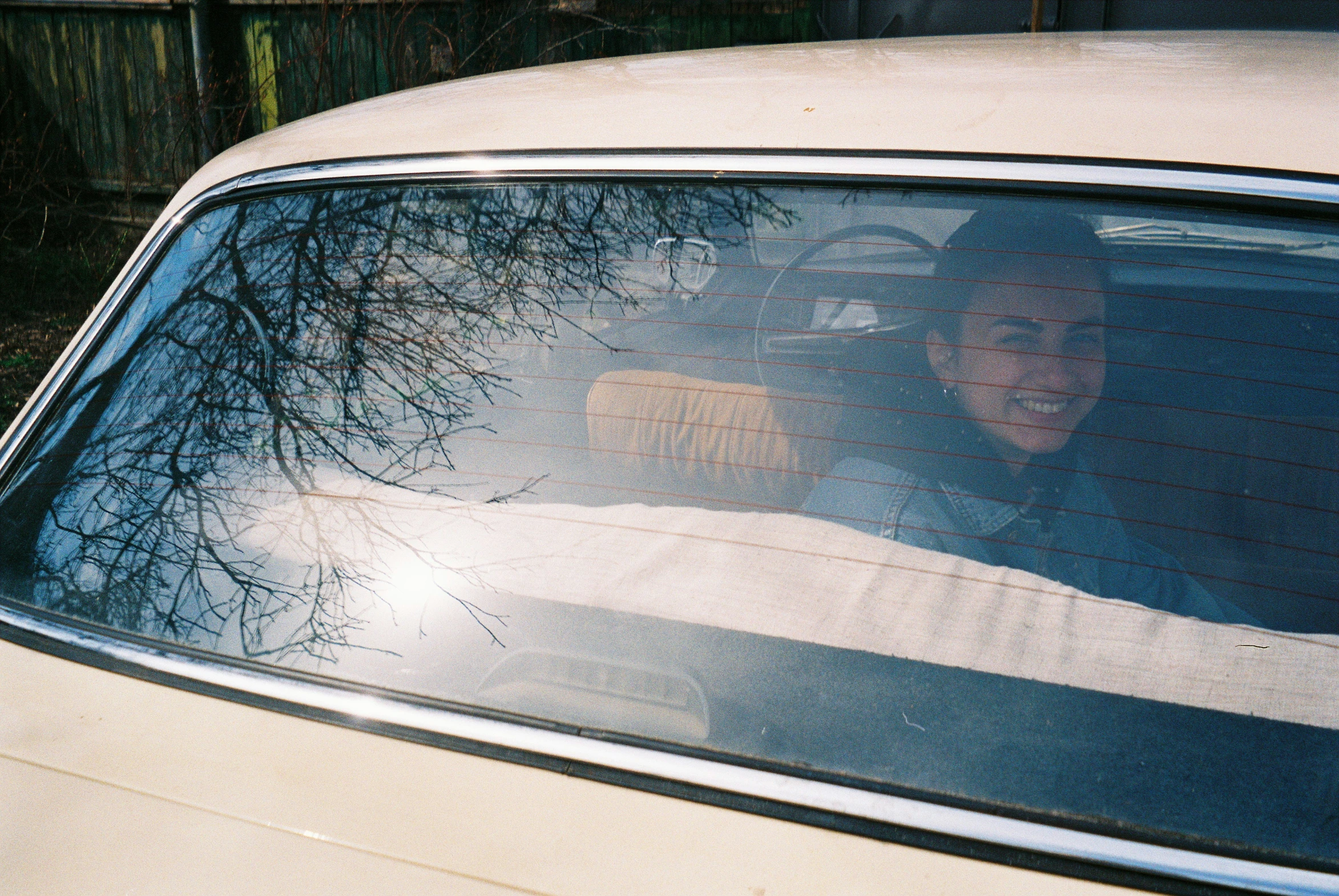 a car is shown with the reflection of the woman in it