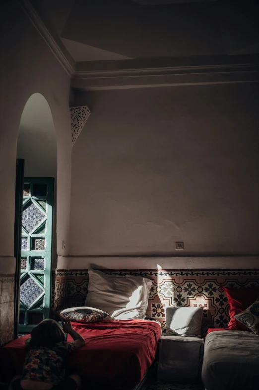 bed with red sheets and an arched doorway