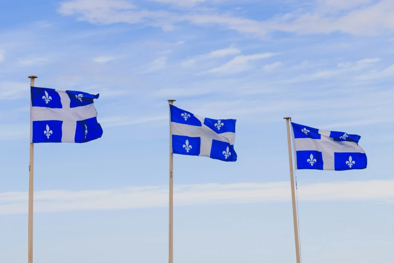 four flag poles with white and blue flags on them