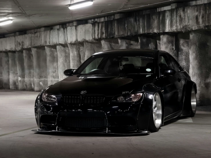 a close - up of a black bmw parked in a parking garage