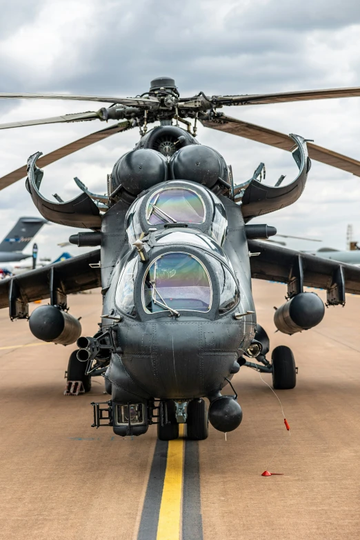 front view of large black military helicopter on runway