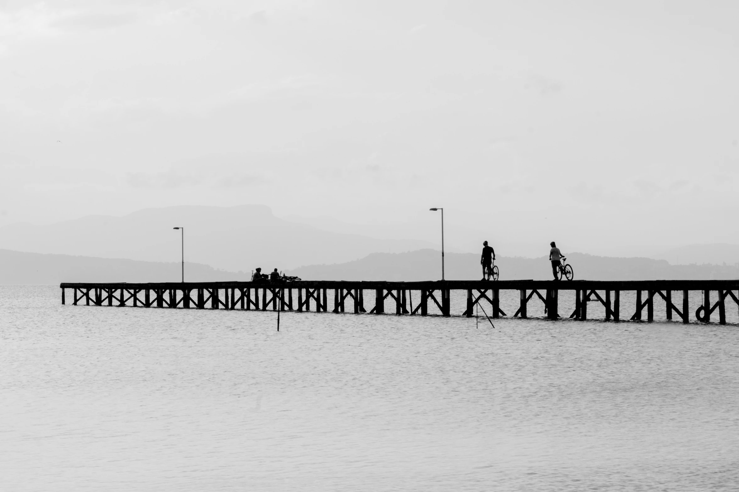 a couple of people on a dock next to the water