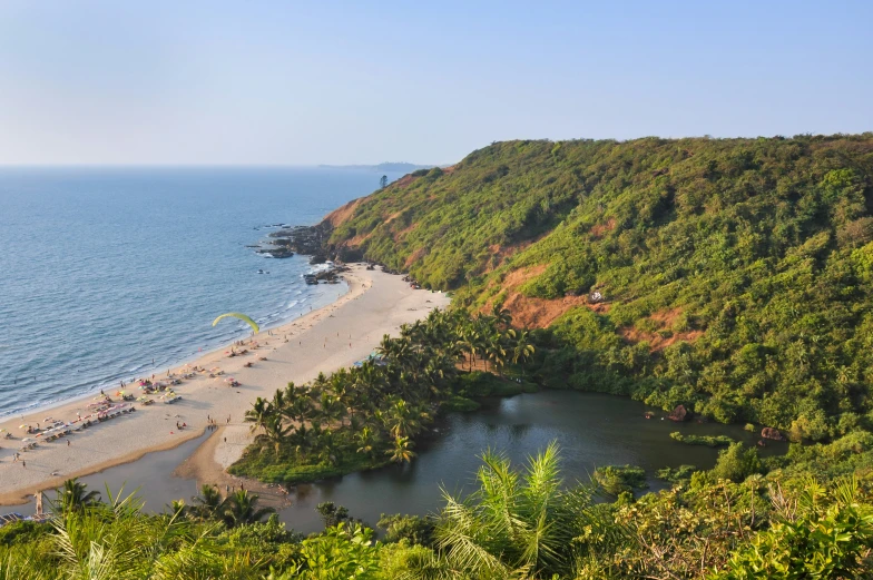 the aerial view of an empty beach area near a hill