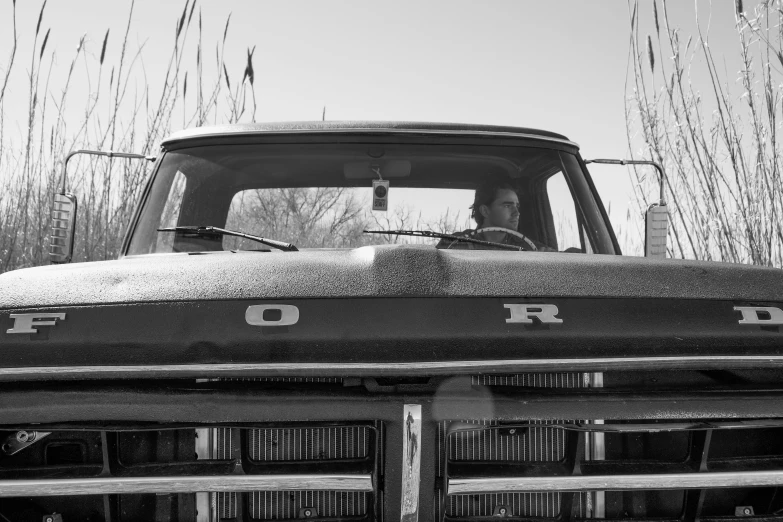 an older truck is covered with snow and grass