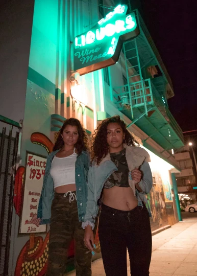 two young women standing on the street outside a building