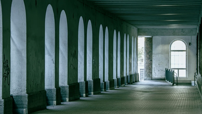 a hallway with a tiled floor and tall columns