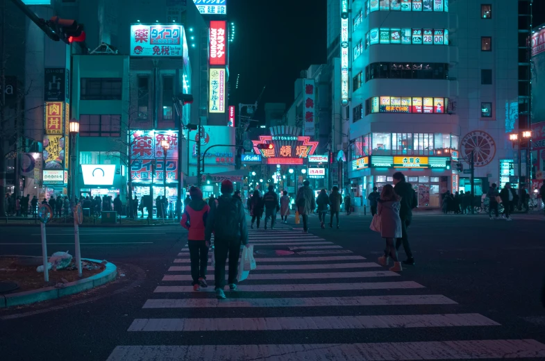 a crosswalk in a city with lots of buildings lit up