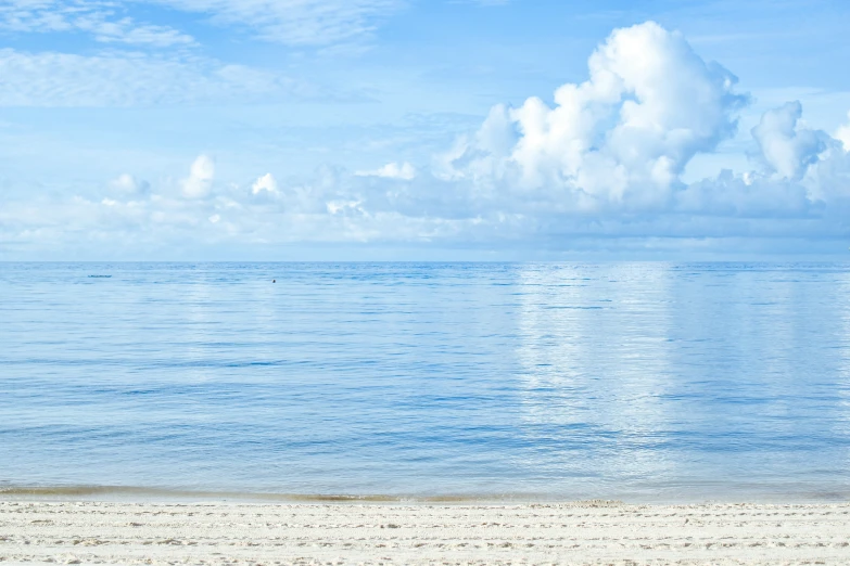 a blue ocean and a lone boat floating on it