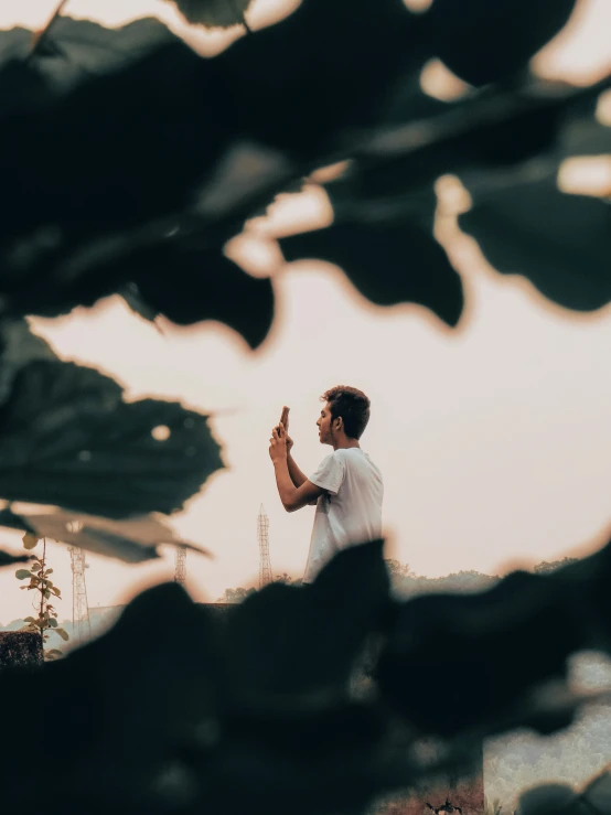 a man standing in the jungle with his hands together