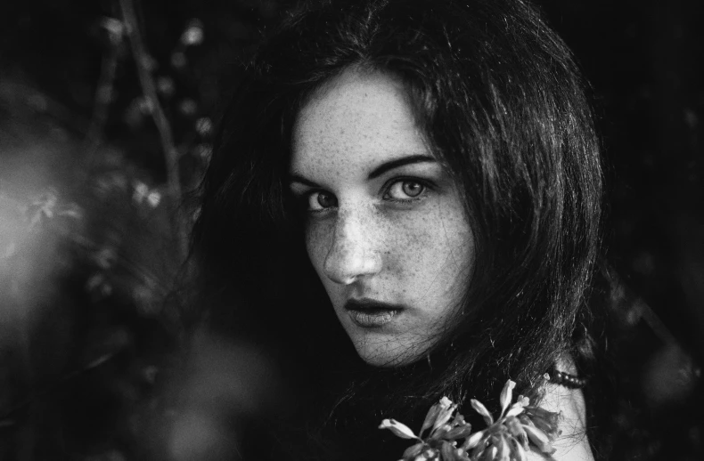 a beautiful young lady with dark hair staring directly at the camera