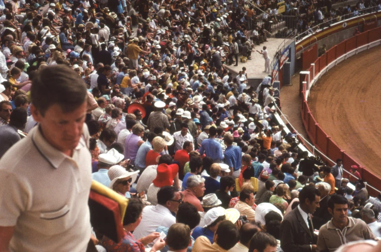 the large crowd is looking down on a rodeo