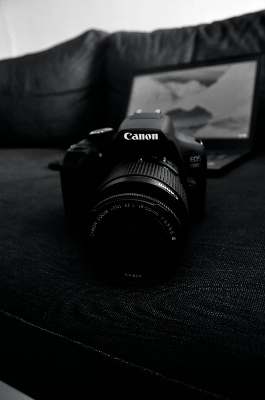 a camera sits on a couch next to an empty tablet