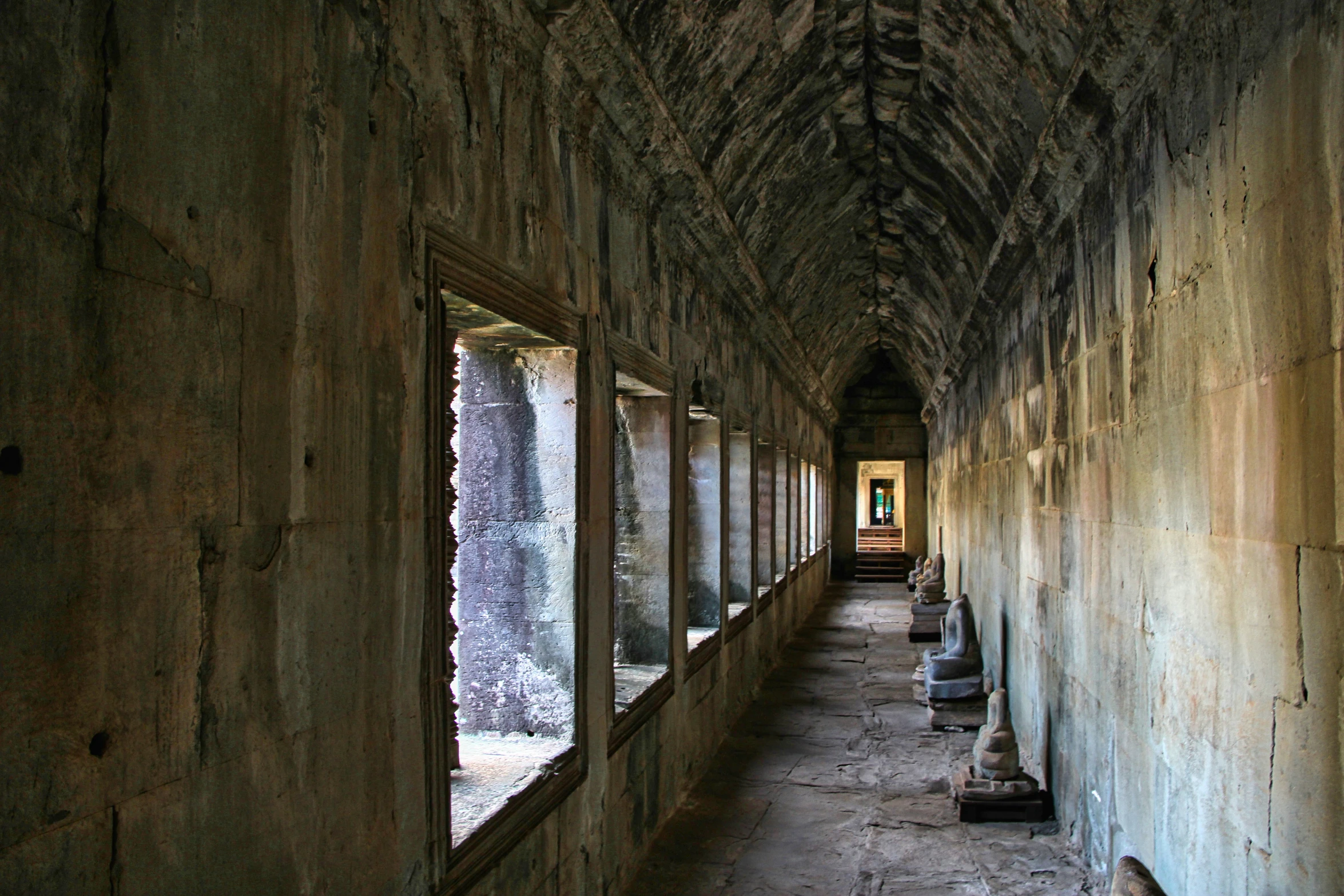 the hallway is lined with old, crumbling windows