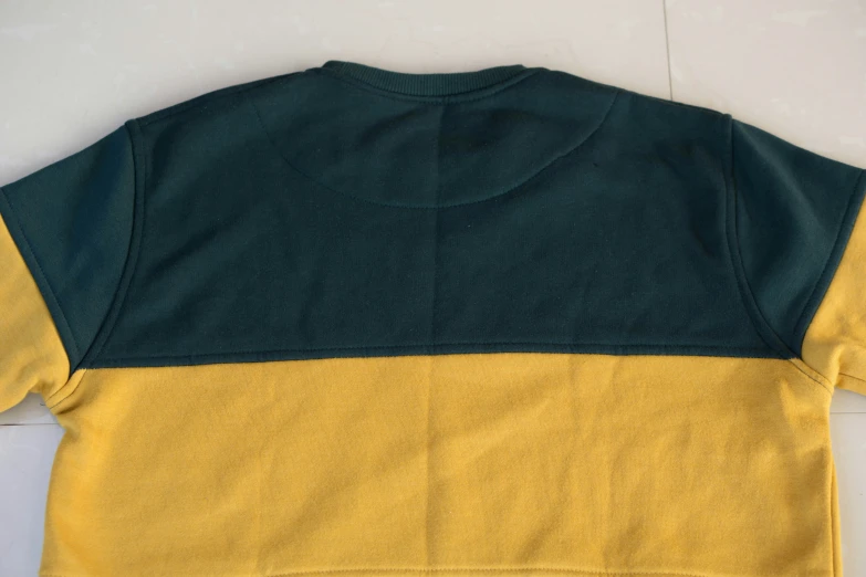 the shirt is yellow and green with two dark grey patches